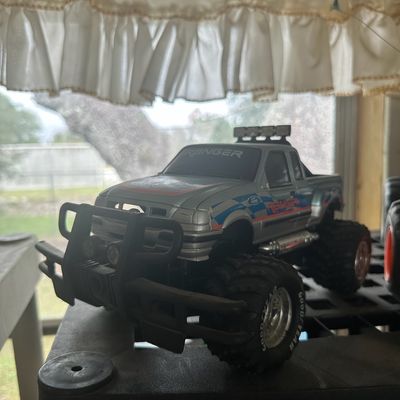 Vintage silver Ford Ranger monster truck toy featuring large Goodyear treaded tires, front bull bar, and roof lights.