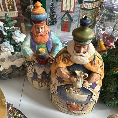 Two Jim Shore Heartwood Creek Wise Men figurines, featuring folk art style painted details, displayed among other holiday collectibles.