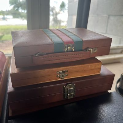 Stack of vintage portable carrying cases, including a leatherette-wrapped case with a Gucci-style stripe accent and two wood/faux-leather...