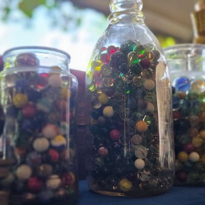 Assorted Glass Marbles in Vintage Jars