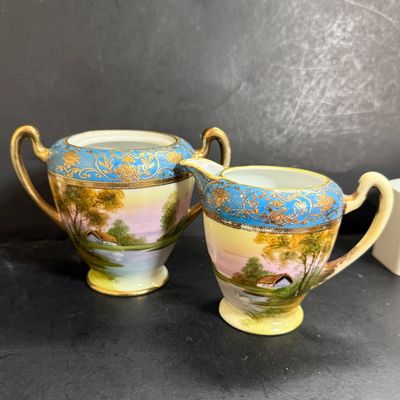 LOT 125: Collection of Painted Nippon Porcelain- Creamers, Pitcher, Plates and More