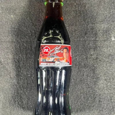 Unopened Tony Stewart 2002 NASCAR Champion commemorative Coca-Cola bottle, featuring his portrait and the number 20 car on the label.