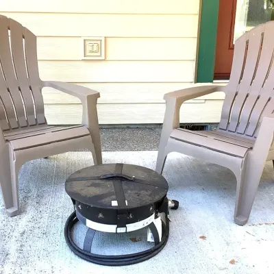 (2) Plastic Chairs With A Portable Gas Fire Pit