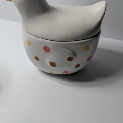 Sale Photo Thumbnail #140: The TAG (often sold as Tag Kitchen) Polka Dot Chicken Covered Nesting Candy Dishes feature a whimsical, dual-compartment design. Made of ceramic, these brightly colored lidded bowls measure roughly 5 inches long and 6.5 inches tall, making them ideal coun