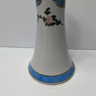 Sale Photo Thumbnail #82: This Antique Nippon Hat Pin Holder features beautifully detailed, hand-painted florals set against a light blue band and accented with elegant gold trim. Made in Japan during the late 19th or early 20th century, these delicate porcelain vanity pieces are 