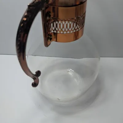 Sale Photo Thumbnail #11: The vintage Princess House copper and brass coffee carafe with stand is a popular 1960s and 1970s mid-century piece designed for elegant tabletop coffee or tea service