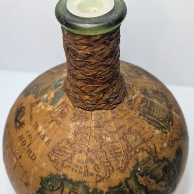 Sale Photo Thumbnail #29: Vintage 1960s leather-wrapped world map bottles are iconic mid-century barware collectibles. Most were handcrafted in Italy (particularly Florence) as decorative decanters for wine or liquor

Materials: Green or brown glass bottles encased in genuine, hea