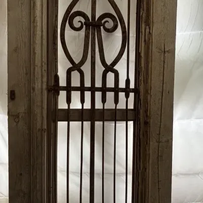 Sale Photo Thumbnail #517: Up for sale is an impressive pair of rustic architectural doors featuring decorative turned wrought iron scroll grilles and hinged inner ventilation frames. 

These classic Mediterranean / French Country / Spanish Colonial style doors work exceptionally w