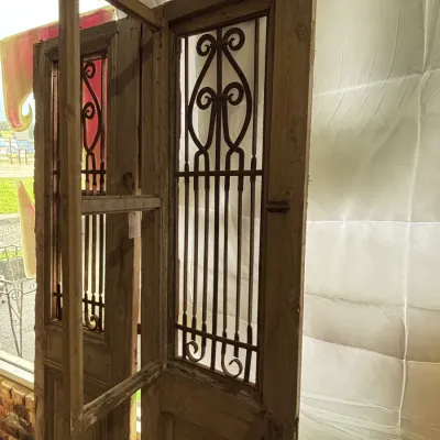 Sale Photo Thumbnail #522: Up for sale is an impressive pair of rustic architectural doors featuring decorative turned wrought iron scroll grilles and hinged inner ventilation frames. 

These classic Mediterranean / French Country / Spanish Colonial style doors work exceptionally w
