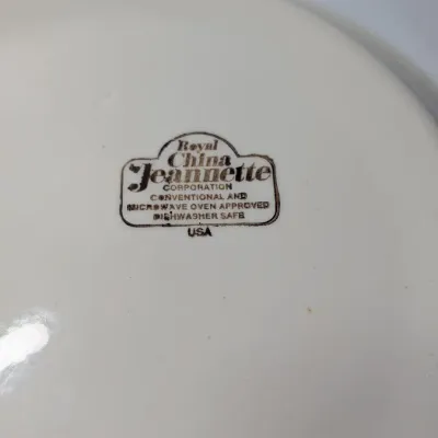 Sale Photo Thumbnail #151: The vintage 1982 Royal China by Jeannette 11" Apple Pie Recipe Plate is a highly collectible, oven-to-table ceramic dish. Featuring a fluted edge and a distinct green and brown apple motif, it lists the exact ingredient amounts and baking instructions dir
