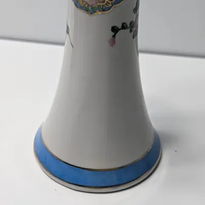 Sale Photo Thumbnail #79: This Antique Nippon Hat Pin Holder features beautifully detailed, hand-painted florals set against a light blue band and accented with elegant gold trim. Made in Japan during the late 19th or early 20th century, these delicate porcelain vanity pieces are 