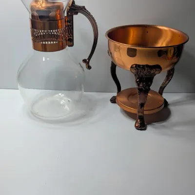 Sale Photo Thumbnail #3: The vintage Princess House copper and brass coffee carafe with stand is a popular 1960s and 1970s mid-century piece designed for elegant tabletop coffee or tea service