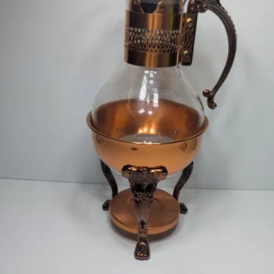 Sale Photo Thumbnail #2: The vintage Princess House copper and brass coffee carafe with stand is a popular 1960s and 1970s mid-century piece designed for elegant tabletop coffee or tea service
