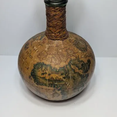 Sale Photo Thumbnail #25: Vintage 1960s leather-wrapped world map bottles are iconic mid-century barware collectibles. Most were handcrafted in Italy (particularly Florence) as decorative decanters for wine or liquor

Materials: Green or brown glass bottles encased in genuine, hea