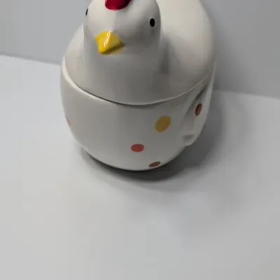 Sale Photo Thumbnail #136: The TAG (often sold as Tag Kitchen) Polka Dot Chicken Covered Nesting Candy Dishes feature a whimsical, dual-compartment design. Made of ceramic, these brightly colored lidded bowls measure roughly 5 inches long and 6.5 inches tall, making them ideal coun