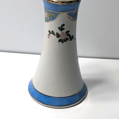 Sale Photo Thumbnail #78: This Antique Nippon Hat Pin Holder features beautifully detailed, hand-painted florals set against a light blue band and accented with elegant gold trim. Made in Japan during the late 19th or early 20th century, these delicate porcelain vanity pieces are 