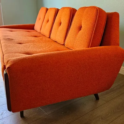 MCM Adrian Pearsall-style Gondola Sofa in Vibrant Textured Orange Fabric with Walnut Wood Accents.