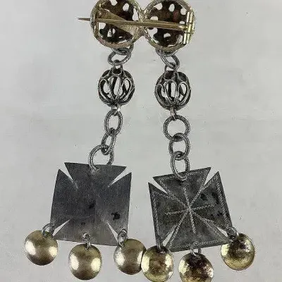 Sale Photo Thumbnail #161: Antique Norwegian Solje Cross brooch featuring traditional 19th-century craftsmanship, including the historic extended C-clasp. Designed with classic Solje elements such as iron-cross motifs and protective dangling gold-vermeil discs that reflect light—