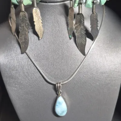 Sale Photo Thumbnail #334: Vintage LARIMAR Pendant w/ Italy 925 snake chain & Native American Feather Earrings
> Larimar in a silver bezel, found Exclusively in Dominican Republic, is a rare blue / white marbling
> snake chain marked Italy & 925.....toned to luster
> earrings are c