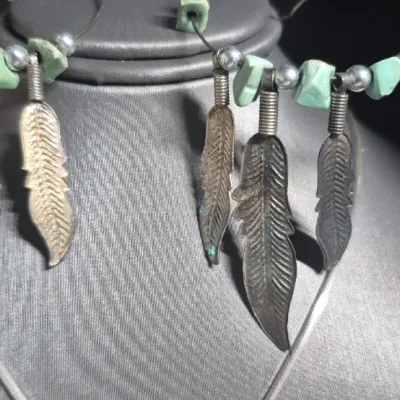 Sale Photo Thumbnail #339: Vintage LARIMAR Pendant w/ Italy 925 snake chain & Native American Feather Earrings
> Larimar in a silver bezel, found Exclusively in Dominican Republic, is a rare blue / white marbling
> snake chain marked Italy & 925.....toned to luster
> earrings are c