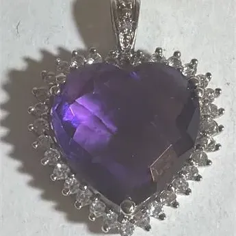 Sale Photo Thumbnail #136: Elegant Amethyst Heart Pendant .925 Sterling Silver 3.76 g
sterling marked snake chain 18" length w/ pendant
Pendant is sparkling topaz w/ ring of Rhinestones set in silver tone casing.