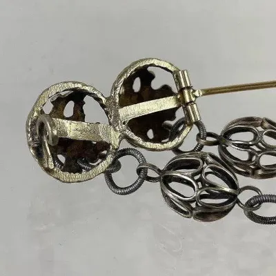 Sale Photo Thumbnail #163: Antique Norwegian Solje Cross brooch featuring traditional 19th-century craftsmanship, including the historic extended C-clasp. Designed with classic Solje elements such as iron-cross motifs and protective dangling gold-vermeil discs that reflect light—