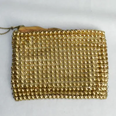 Sale Photo Thumbnail #341: Coin purse is attributed to Whiting & Davis and features a gold-tone mesh construction accented with gold beading and a secure zipper closure. The interior is lined with complimentary pink fabric. The piece measures approximately 4" H x 5" W x 1/4" D.....