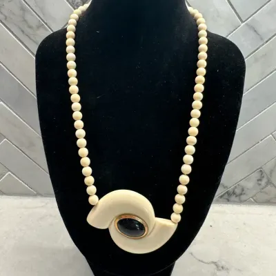 Sale Photo Thumbnail #364: vintage Crown Trifari "hurricane" pendant necklace featuring a white lucite swirl design and a gold-tone accent.
excellent condition, rare to find, overall 16" length.
no damage, chips or repairs......as is original