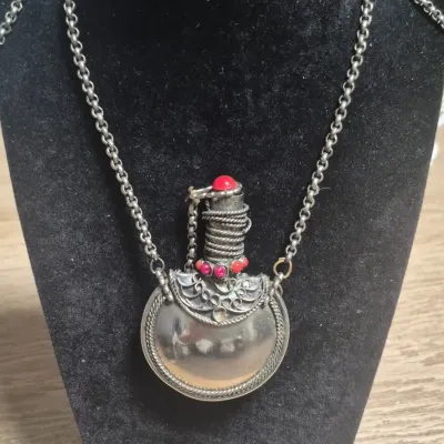 Sale Photo Thumbnail #24: Navajo Indian sterling / coral flask with continuous neck chain...no clasp

Size approx. 3" by 2"d / 1/2 thick.

Neck chains is 32" long.

Stopper fits loosely for using it....decorative

Great display item for collector's display......wonderful details