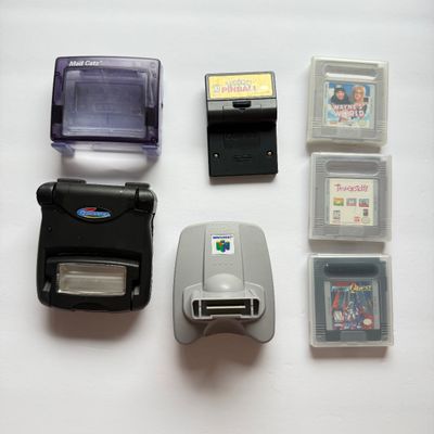 LOT 203V: Vintage Nintendo GameBoy Games & Accessories: Tamagotchi, Wayne's World, Power Quest, N64 Adapter & Clip-on Lighting