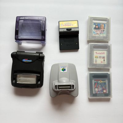 LOT 203V: Vintage Nintendo GameBoy Games & Accessories: Tamagotchi, Wayne's World, Power Quest, N64 Adapter & Clip-on Lighting