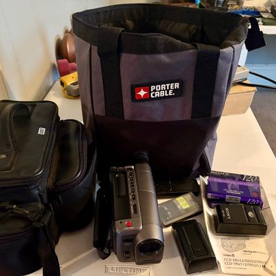 Sale Photo Thumbnail #306: This lot includes a Sony Handycam, tapes, cords, manual and the original carrying case along with a bag of accessories. In good working condition.
