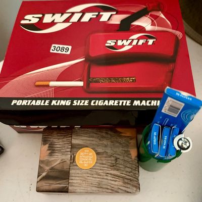 Sale Photo Thumbnail #375: Lot includes Portable king size cigarette machine. New in original box, in perfect condition. Boxes of rolling papers and hard case included.