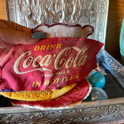 Vintage embroidered "Drink Coca-Cola In Bottles" uniform patch, displayed alongside other vintage patches inside a decorated...