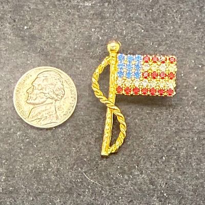 Sale Photo Thumbnail #565: Gold tone pin with red, white and blue rhinestones. Good condition.