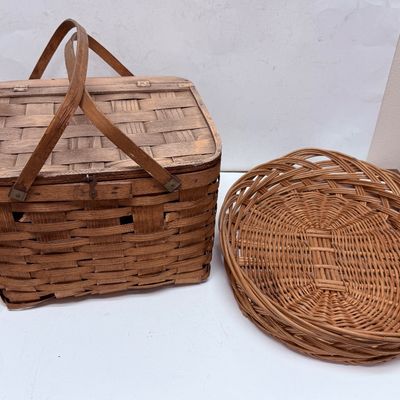 Sale Photo Thumbnail #12: The picnic basket appears to be very old. Has a hinged lid, and a small platform inside with 4 legs, remnant of pale pink paint on the lid. The oval one is in very good condition.