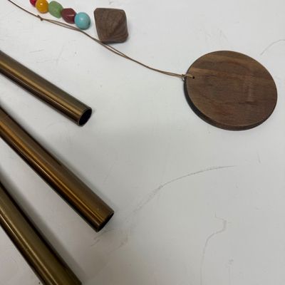 Sale Photo Thumbnail #271: Copper tubes and a central cord holding colored beads and a wood striker.  All parts included except 2 of the colored stones are missing. Wind chime needs the chime tube hanging cords and central chime striker cord reattached. Last photo shows a properly 