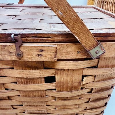 Sale Photo Thumbnail #17: The picnic basket appears to be very old. Has a hinged lid, and a small platform inside with 4 legs, remnant of pale pink paint on the lid. The oval one is in very good condition.