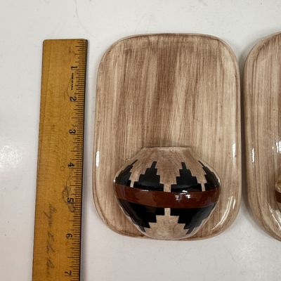 Sale Photo Thumbnail #64: Pair of ceramic plaques made to look like a wood plaque with a small woven southwestern basket.  Each is about the size of a standard light switch, good condition.