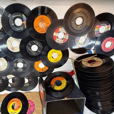 Sale Photo Thumbnail #413: The rack is in very good condition, the case is in fair condition with lots of writing, and the records range in condition from poor to good condition. Also 3 spindle spacers included.