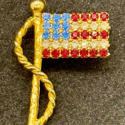 Sale Photo Thumbnail #566: Gold tone pin with red, white and blue rhinestones. Good condition.