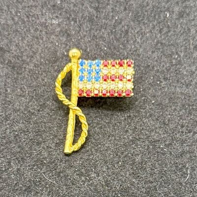 Sale Photo Thumbnail #564: Gold tone pin with red, white and blue rhinestones. Good condition.