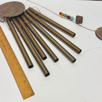 Sale Photo Thumbnail #269: Copper tubes and a central cord holding colored beads and a wood striker.  All parts included except 2 of the colored stones are missing. Wind chime needs the chime tube hanging cords and central chime striker cord reattached. Last photo shows a properly 
