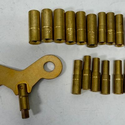 Sale Photo Thumbnail #380: Universal brass clock keys for winding clocks; this clock key set includes 18 sizes from 000 to 15. One handle is supplied with replaceable female bits to fit nearly all winding clocks. Like-new condition in plastic storage box.