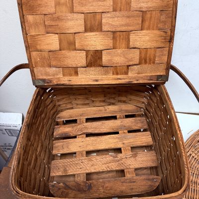 Sale Photo Thumbnail #15: The picnic basket appears to be very old. Has a hinged lid, and a small platform inside with 4 legs, remnant of pale pink paint on the lid. The oval one is in very good condition.
