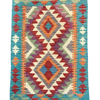 Colorful geometric flatweave rug with bold diamond pattern in turquoise, orange, red, and ivory