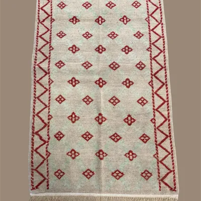 Light neutral rug with simple red geometric pattern