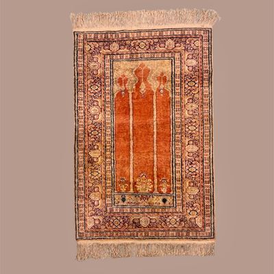 Small rust and ivory traditional rug with ornate border and fringe