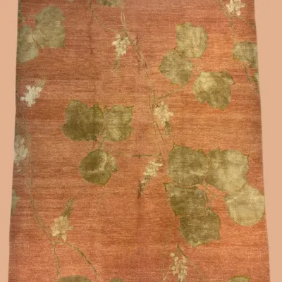 Warm rust-toned area rug with subtle green botanical design