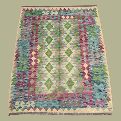 Colorful geometric flatweave rug with green, purple, blue, and ivory diamond motifs